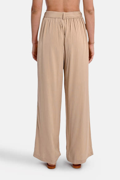 Beige broek van Molly Bracken, losse pasvorm, licht gekreukte textuur, met bijpassende riem en zichtbare bruine schoenen.