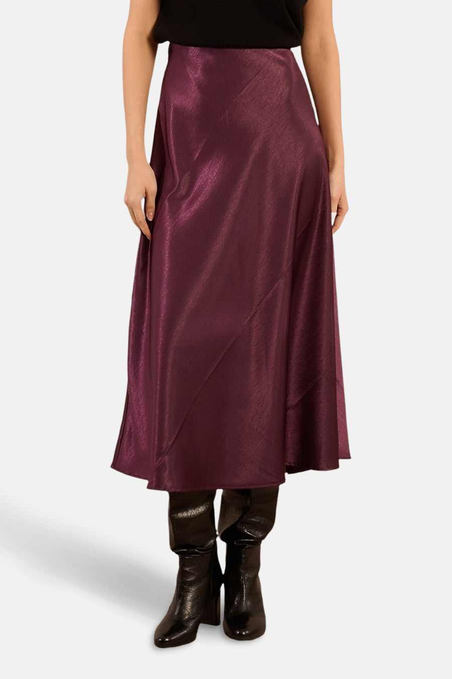 Glanzende paarse lange rok van Molly Bracken, met asymmetrische zoom en gedragen met zwarte laarzen.
