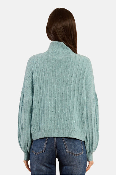 Blauwe coltrui van Molly Bracken met ribtextuur en glitterdetails, gedragen met een spijkerbroek.
