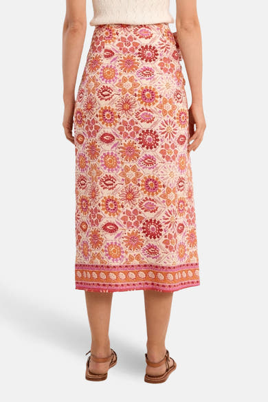 Jupe longue multicolore de Molly Bracken, à motif floral, portée avec des sandales à brides.