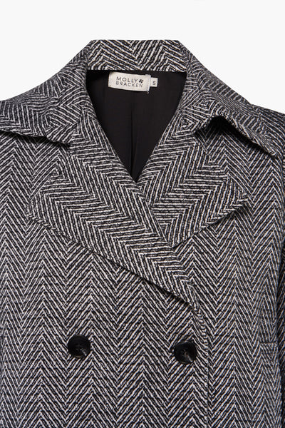 Veste courte noire à chevrons de Molly Bracken, avec col à revers et fermeture croisée boutonnée.