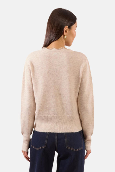 Beige vest van Molly Bracken, met een kanten rand rond de hals en gedragen met een donkerblauwe jeans.