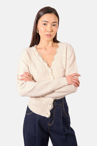 Beige cardigan van Molly Bracken, versierd met kant, gedragen met een marineblauwe high-waist jeans.