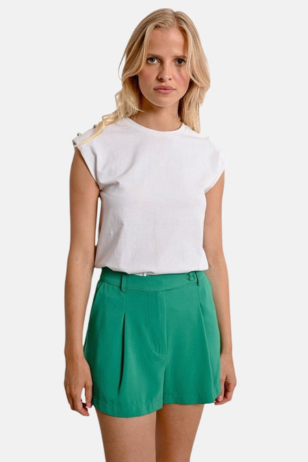 Witte T-shirt met korte mouwen van Molly Bracken, met knoopdetail op de schouders, gedragen met een groene korte broek.