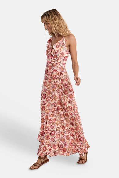 Robe multicolore de Molly Bracken avec motif floral, col à volant, et sandales marron portées.