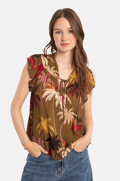 Blouse à manches courtes multicolore de Molly Bracken, imprimé avec des motifs de palmiers, portée avec un jean.
