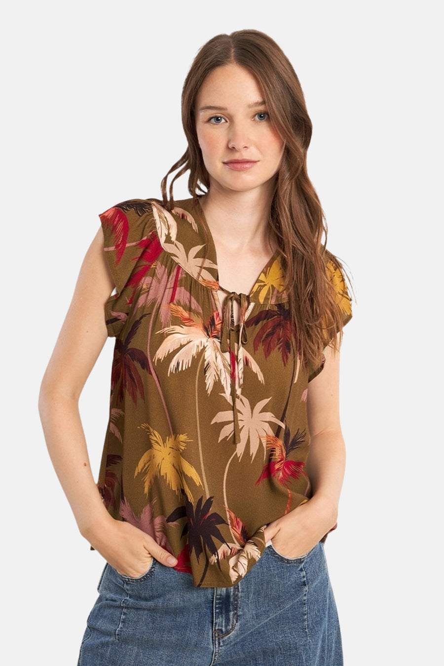 Blouse à manches courtes multicolore de Molly Bracken, imprimé avec des motifs de palmiers, portée avec un jean.
