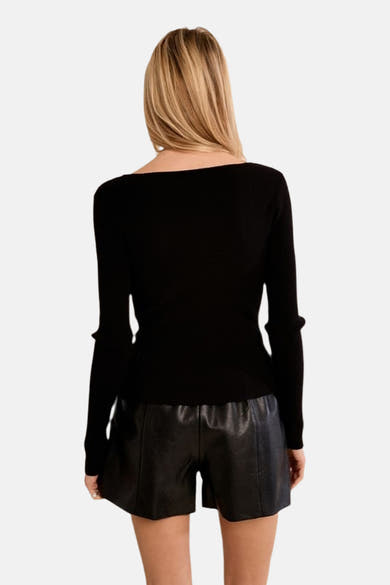 Black ribbed long-sleeve crewneck sweater back view, worn with shiny black shorts