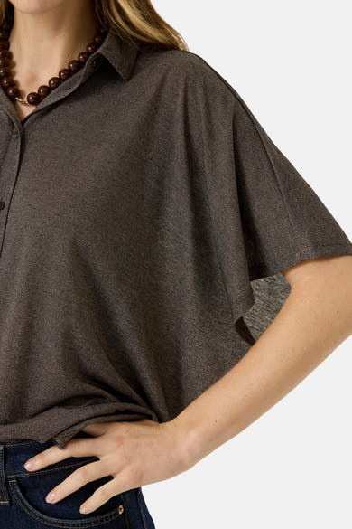 Brown 3/4-sleeve blouse with textured fabric, button-down collar, and side view styling worn with dark jeans and wooden bead necklace.