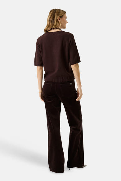 Brown V-neck short-sleeve knit sweater back view with ribbed hem and cuffs, worn with matching corduroy pants and beaded necklace.