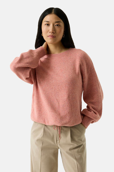 Coral crewneck sweater with soft textured knit, relaxed fit, and ribbed cuffs, worn with beige pants in front view