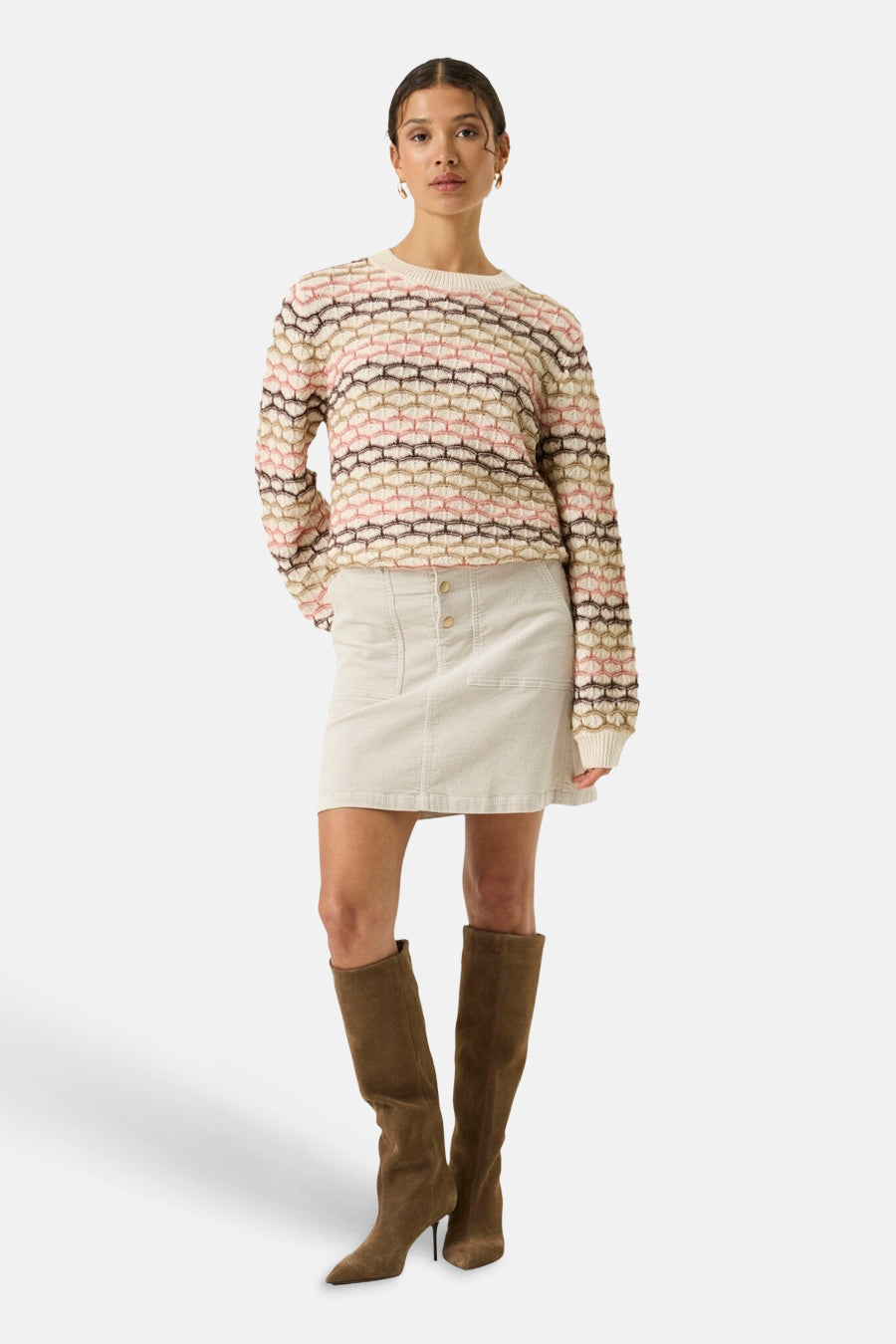 Ecru crewneck sweater with multicolor geometric knit pattern, worn with cream skirt and brown boots, full-length front view