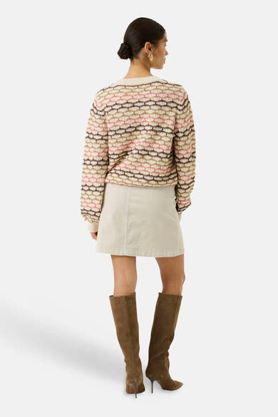Ecru O-neck sweater with pink and brown geometric knit pattern, back view, worn with cream skirt and brown suede boots