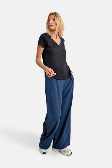 Zwart T-shirt met korte mouwen van Molly Bracken, gedragen met een wijde blauwe broek.
