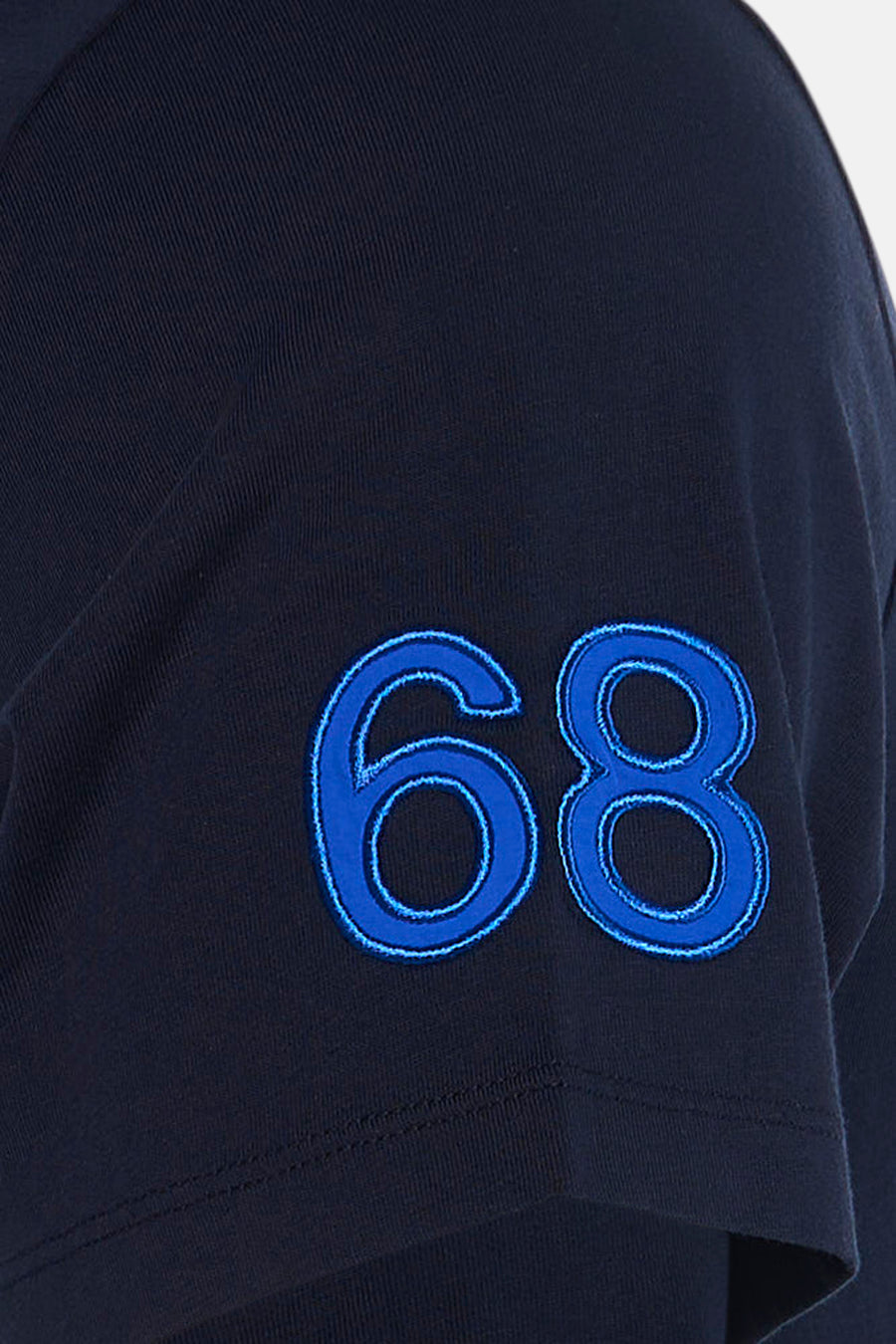 Navy blue short-sleeve t-shirt with bold embroidered "68" in bright blue on the sleeve, close-up side view