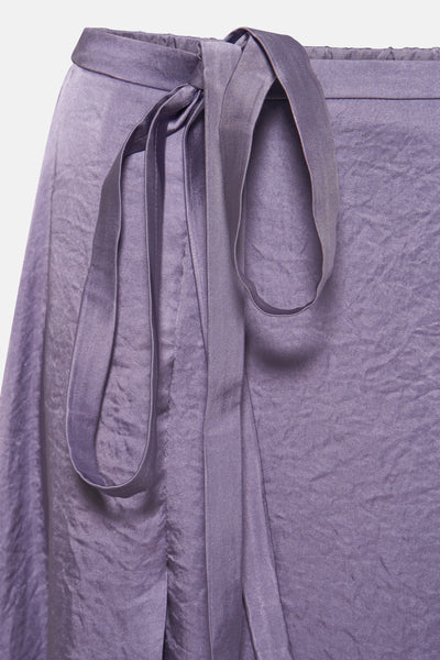Lange paarse TERRE BLEUE satijnen rok, met decoratieve strikceintuur en draperie.
