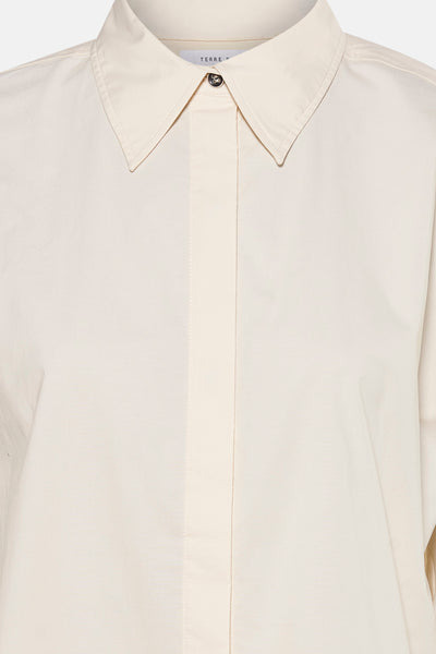 Blouse écru de TERRE BLEUE avec fermeture boutonnée et col classique pointu.
