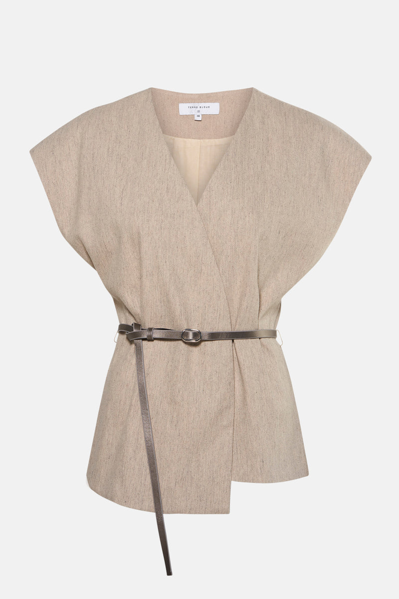 Blazer beige de TERRE BLEUE, avec ceinture métallique et coupe asymétrique.
