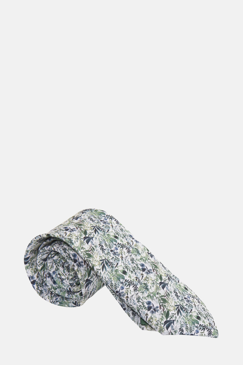 Cravate verte à motifs floraux par MR. CELESTIN, enroulée, avec des feuilles vertes et bleues.