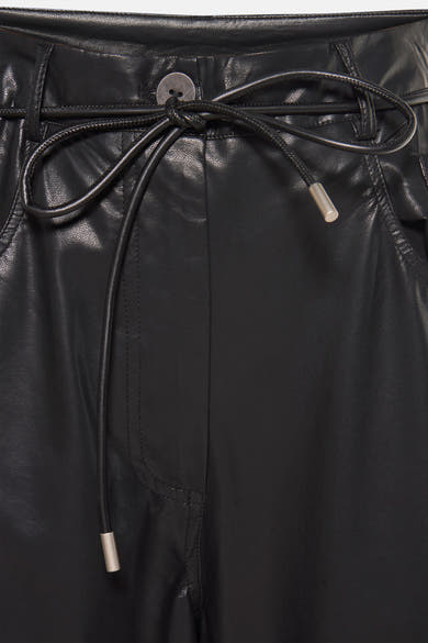 Pantalon noir en similicuir par ADORE avec une ceinture nouée et une texture lisse.