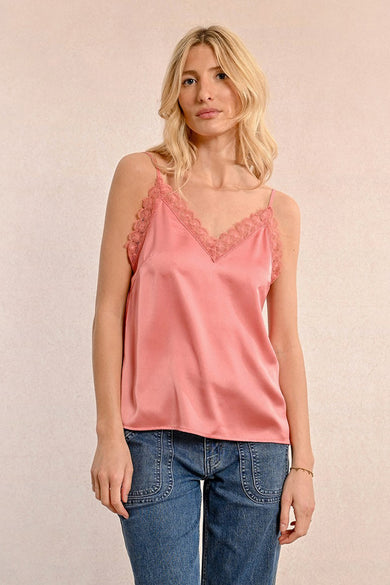 Blouse sans manches rose de Molly Bracken avec dentelle décorative et bretelles fines, portée avec un jean.

