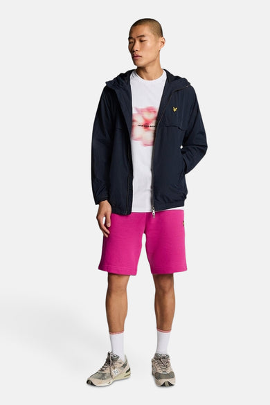 Wit T-shirt met korte mouwen van Lyle & Scott, met vervaagd bloemenpatroon, gedragen met een jasje en een roze korte broek.