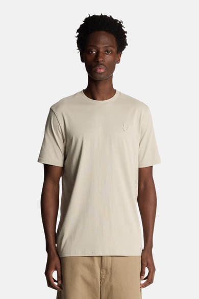 Beige T-shirt met korte mouwen van LYLE & SCOTT, van achteren gezien, gedragen met een camelkleurige korte broek.
