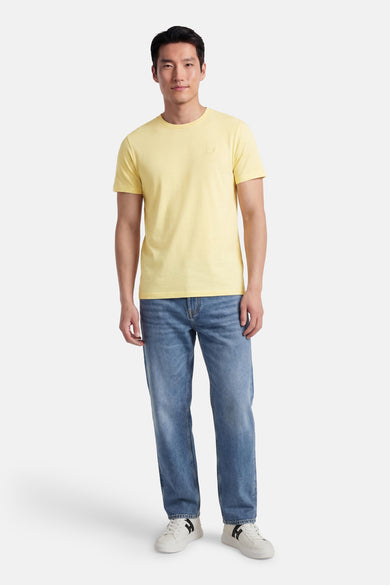 Gele T-shirt met korte mouwen van LYLE & SCOTT, gedragen met een blauwe jeans en witte sneakers