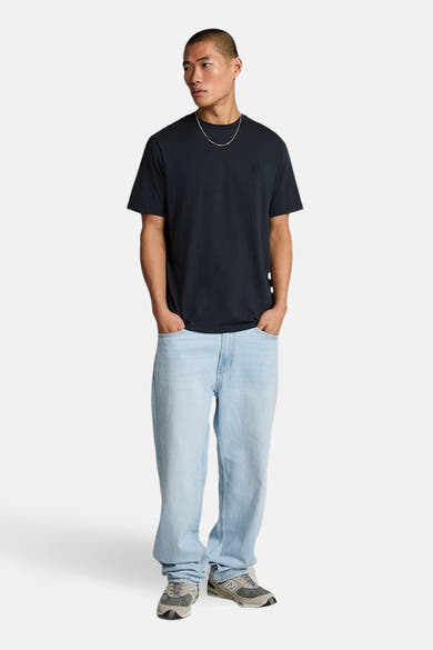 Blauw T-shirt met korte mouwen van LYLE & SCOTT, gedragen met een wijde jeans en grijze sneakers.