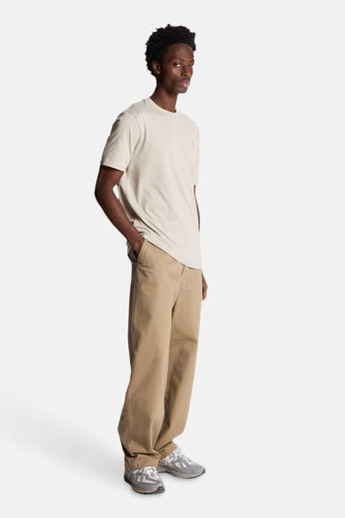 T-shirt à manches courtes gris clair de LYLE & SCOTT, porté avec un pantalon beige et des baskets grises, vue de côté.