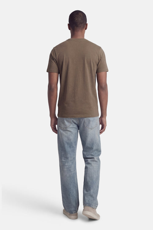 T-shirt à manches courtes kaki de LYLE & SCOTT, porté avec un jean bleu et des baskets couleur crème, vue de dos.