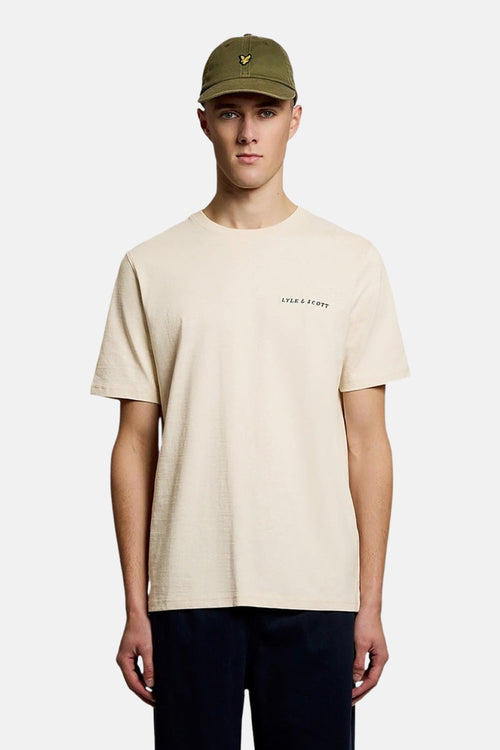 T-shirt à manches courtes écru de Lyle & Scott, porté avec une casquette kaki.
