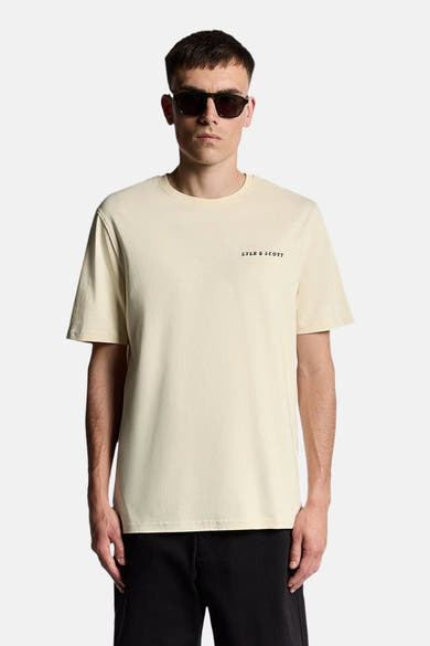 Beige T-shirt met korte mouwen van LYLE & SCOTT, gedragen met een zwarte broek en een zonnebril.