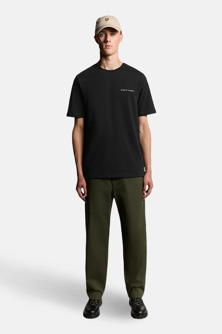 Zwart T-shirt met korte mouwen van LYLE & SCOTT, gedragen met een olijfgroene broek en een beige pet.