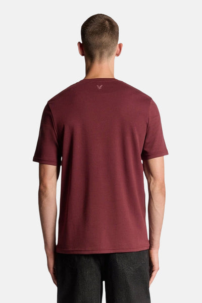 Bordeaux T-shirt met korte mouwen van LYLE & SCOTT, achterkant, gedragen met een zwarte broek.