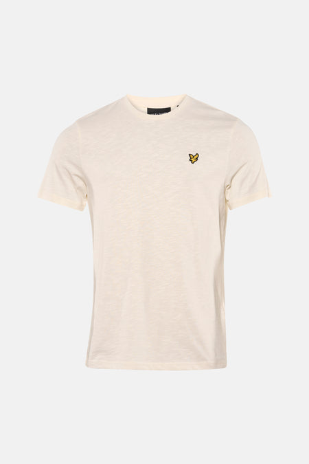 Ecru T-shirt met korte mouwen van LYLE & SCOTT, gedragen met een bruine broek en suède loafers.