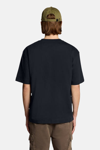 T-shirt bleu marine à manches courtes de LYLE & SCOTT, vu de dos, porté avec une casquette verte et un short cargo marron.