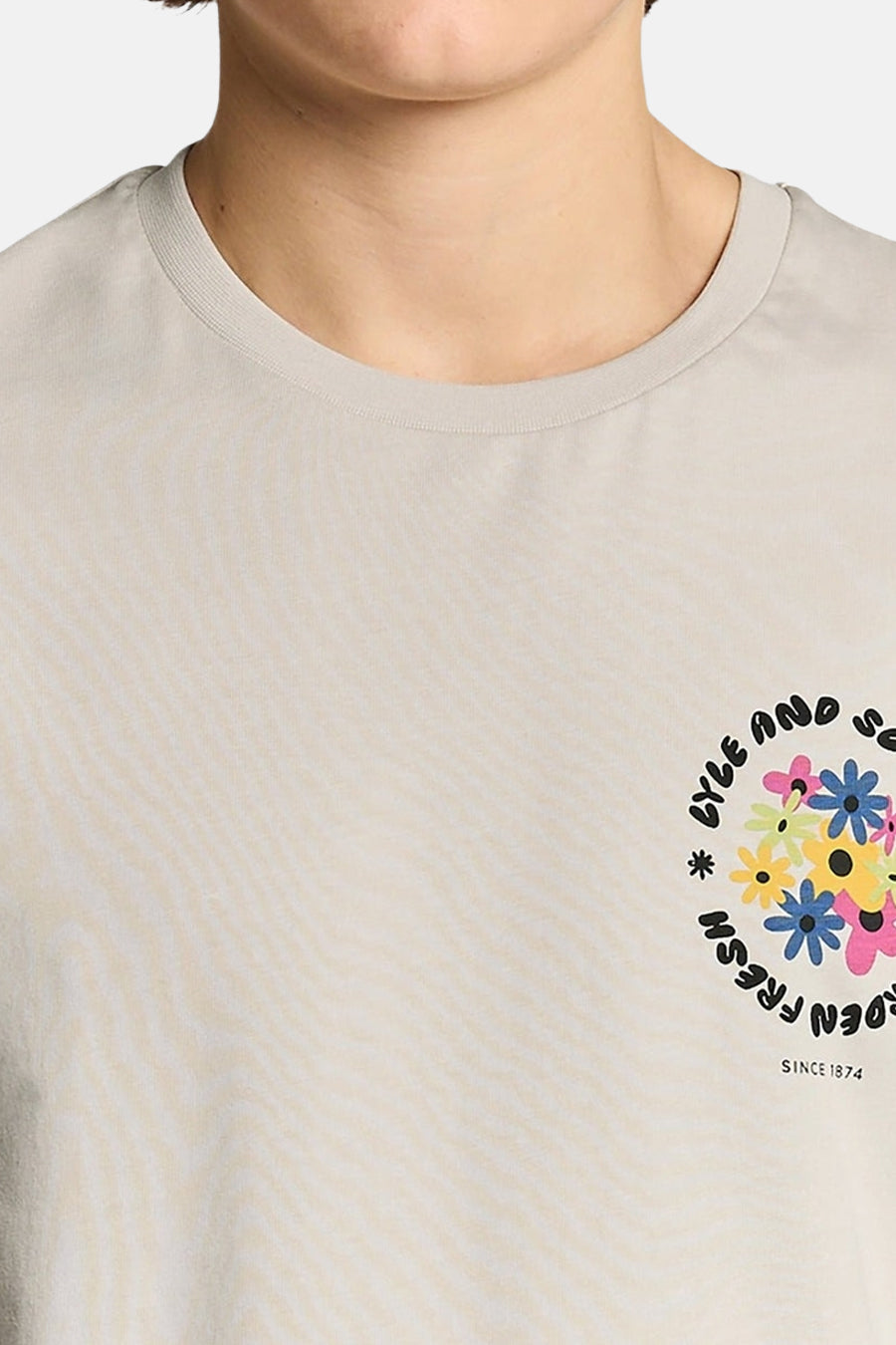 Ecru T-shirt van LYLE & SCOTT, met een cirkelvormig patroon van veelkleurige bloemen en tekst inclusief "SINCE 1874" op de rechterborst.