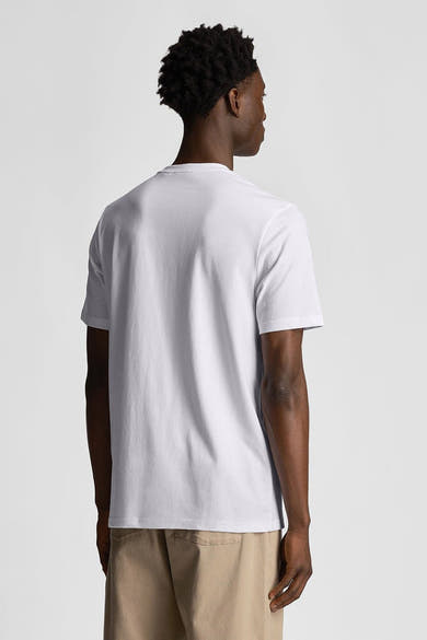 T-shirt blanc à manches courtes de LYLE & SCOTT, vue de dos, porté avec un pantalon couleur sable.
