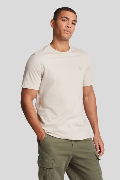 T-shirt à manches courtes beige de LYLE & SCOTT, porté avec un pantalon cargo olive.