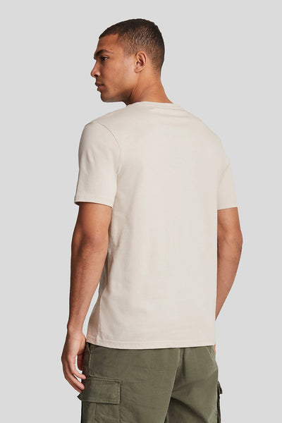 T-shirt à manches courtes beige de LYLE & SCOTT, porté avec un pantalon cargo vert olive, vue de dos.
