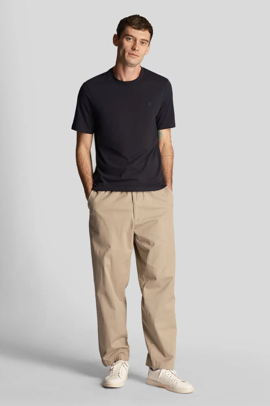 T-shirt bleu de LYLE & SCOTT, porté avec un pantalon chino beige et des baskets blanches.