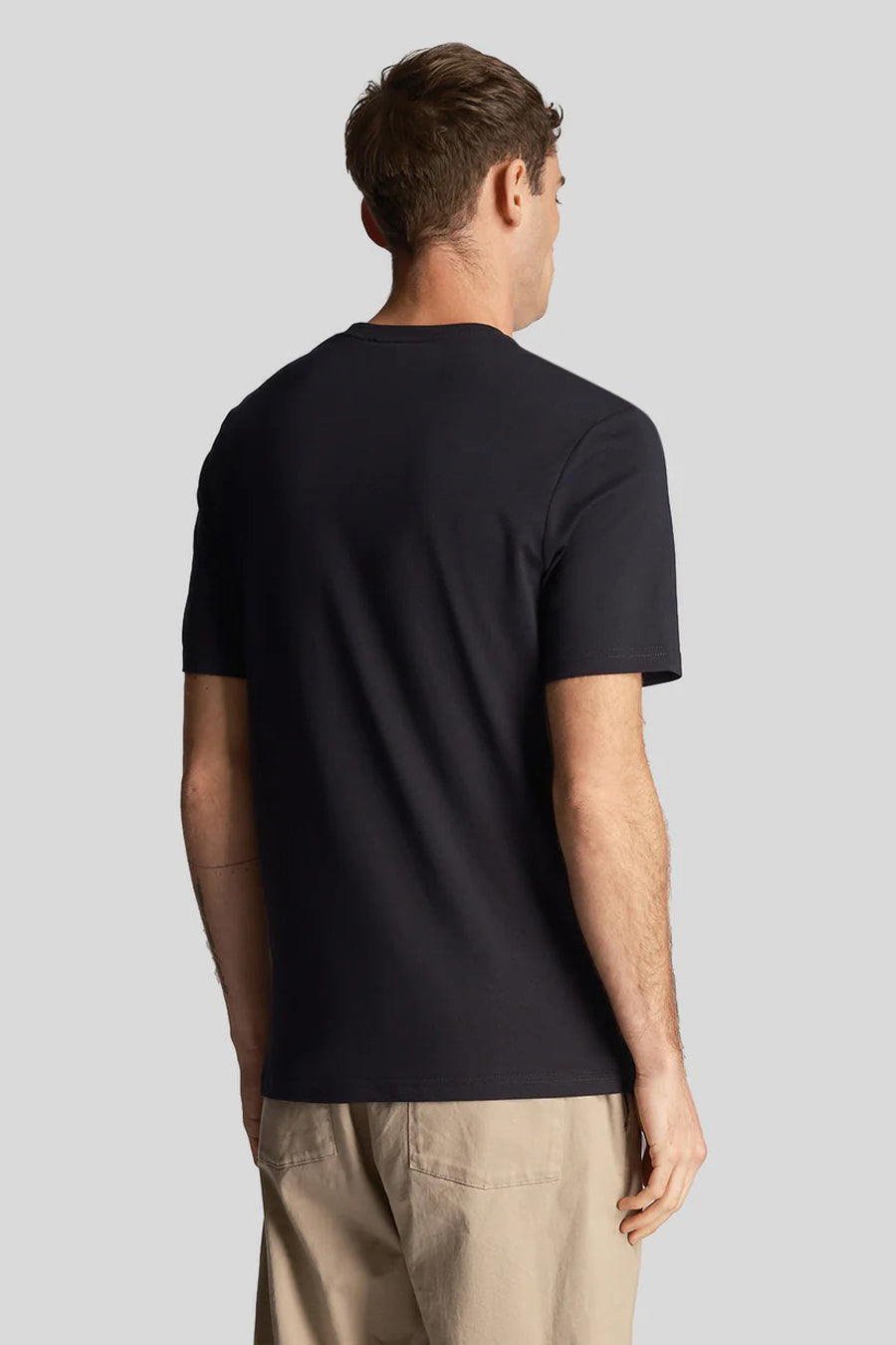 T-shirt bleu marine de LYLE & SCOTT, porté avec un pantalon beige, vue de dos.
