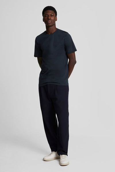 Blauw T-shirt met korte mouwen van LYLE & SCOTT, gedragen met een blauwe broek en witte schoenen.