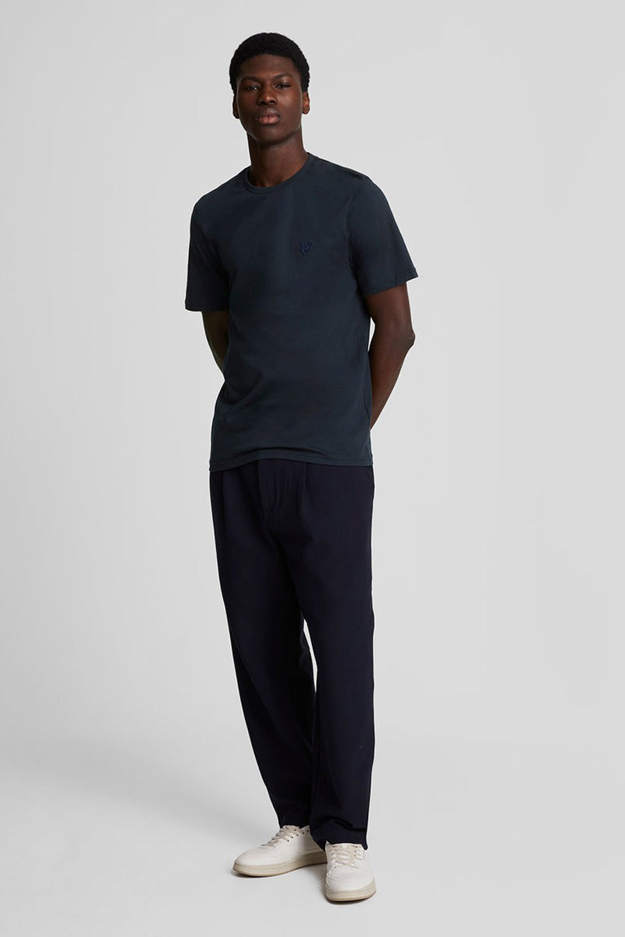 Blauw T-shirt met korte mouwen van LYLE & SCOTT, gedragen met een blauwe broek en witte schoenen.