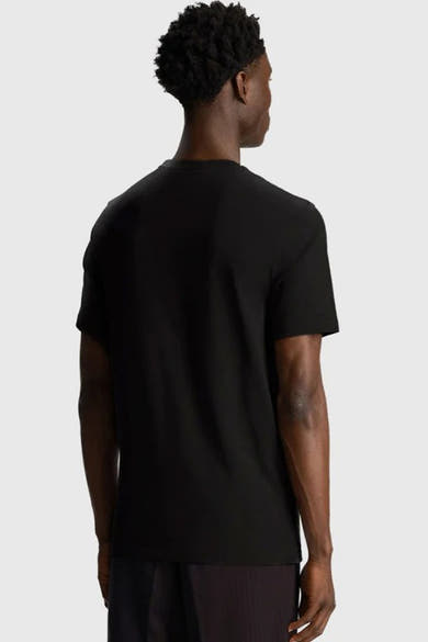 T-shirt noir à manches courtes de LYLE & SCOTT, vue de dos, porté avec un pantalon sombre.
