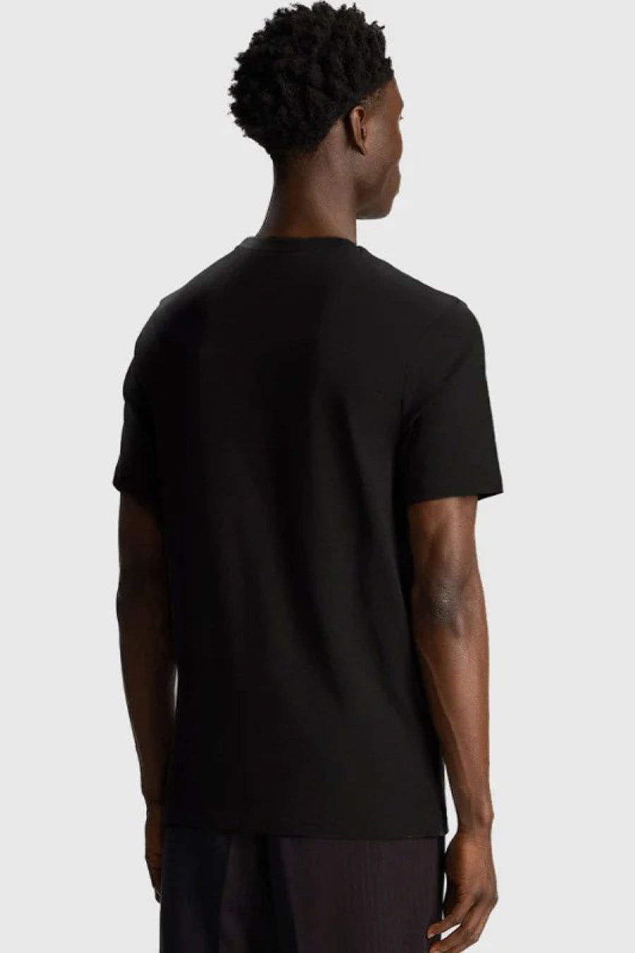 T-shirt noir à manches courtes de LYLE & SCOTT, vue de dos, porté avec un pantalon sombre.