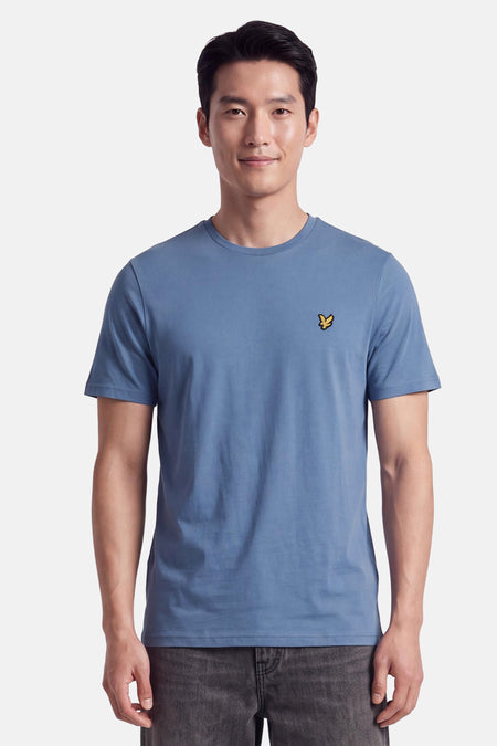 T-shirt bleu à manches courtes par LYLE & SCOTT, col rond, broderie oiseau doré sur poitrine, vue frontale modèle
