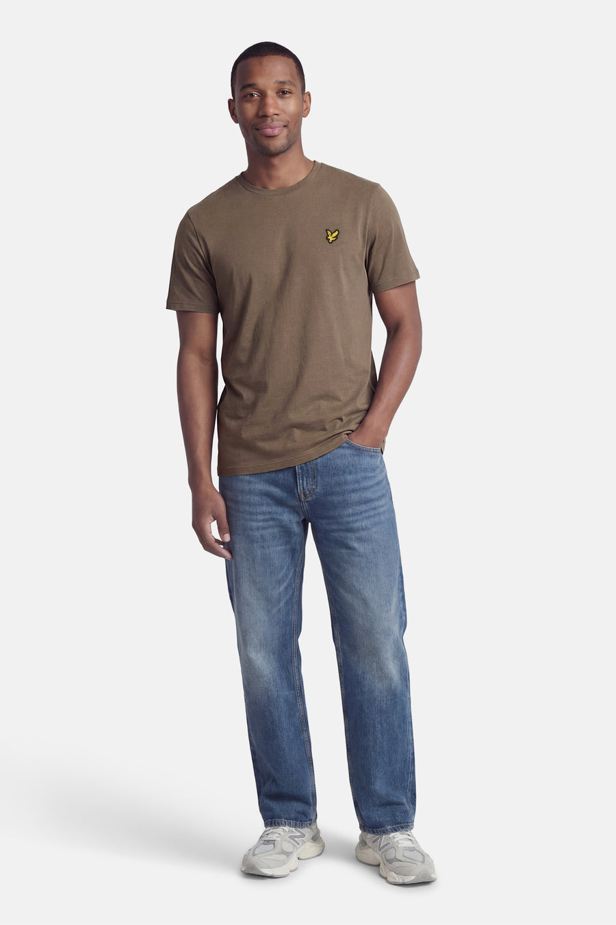 T-shirt kaki à manches courtes de Lyle & Scott, porté avec un jean bleu et des chaussures de sport grises.