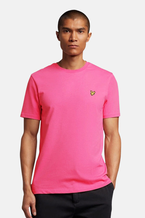 T-shirt rose à manches courtes de LYLE & SCOTT, porté par un homme, avec un logo sur la poitrine.